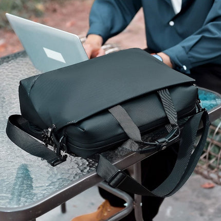 Black backpack with a laptop on a glass table outdoors