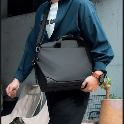 Person holding a black shoulder bag outdoors
