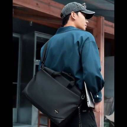 Man carrying a black shoulder bag outdoors