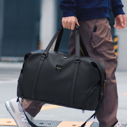 Person carrying a Bokken Travel Bag Large Capacity in a stylish urban setting, ideal for week-long trips.