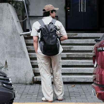Sora Backpack for Biker, Mountain Climbing being worn by a person on stairs in a modern urban setting.