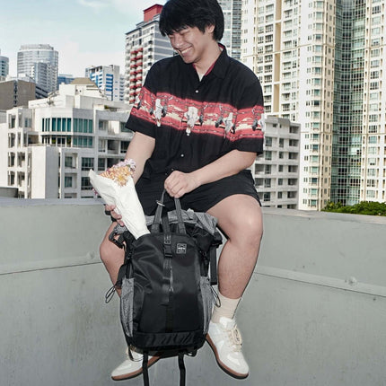 Sora Backpack for Biker, Mountain Climbing with a person holding flowers in an urban setting.