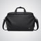 Black duffel bag with shoulder strap on a light gray background