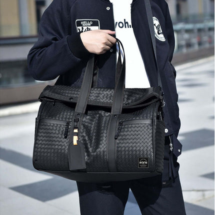 Limited Edition Kaze Woven Duffel Bag & Travel Bag in black with stylish design, held by a person.