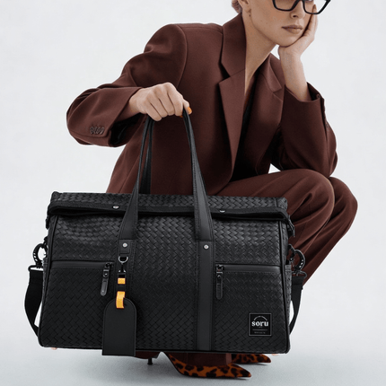 Limited Edition Kaze Woven Duffel Bag & Travel Bag in a stylish black design being carried by a model.