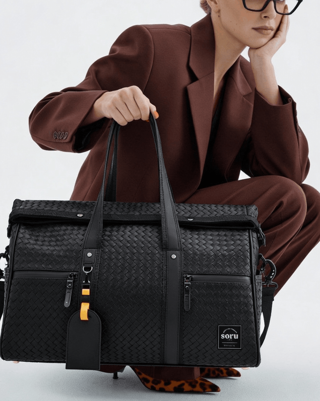 Limited Edition Kaze Woven Duffel Bag & Travel Bag in a stylish black design being carried by a model.