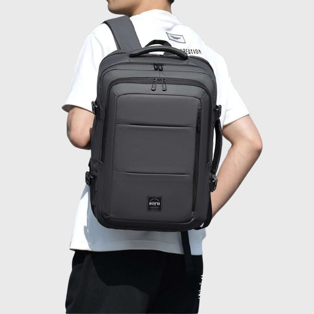 Person wearing a Jobu Backpack Waterproof Travel Bag, showcasing its sleek design and spacious compartments.