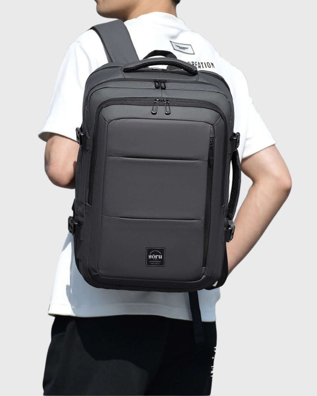 Person wearing a Jobu Backpack Waterproof Travel Bag, showcasing its sleek design and spacious compartments.