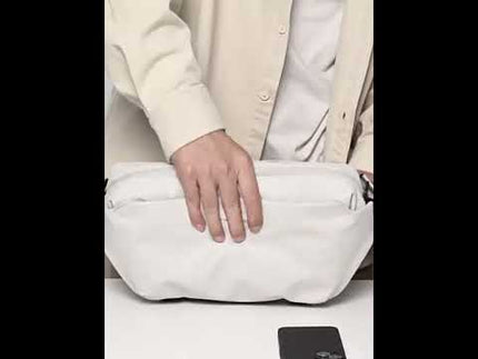 Person using the Noroi Shoulder Bag and Cross Body Bag, showcasing its practical design and storage features.